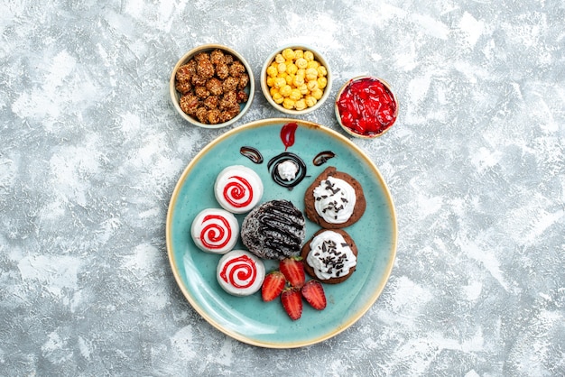 Free Photo top view sweet biscuits with chocolate cake and candies on a white background candy sugar biscuit cake sweet tea