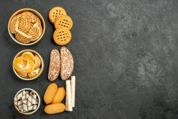 Top view sweet biscuits with cookies and fruits on grey background