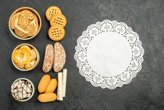 Top view sweet biscuits with cookies and fruits on grey background