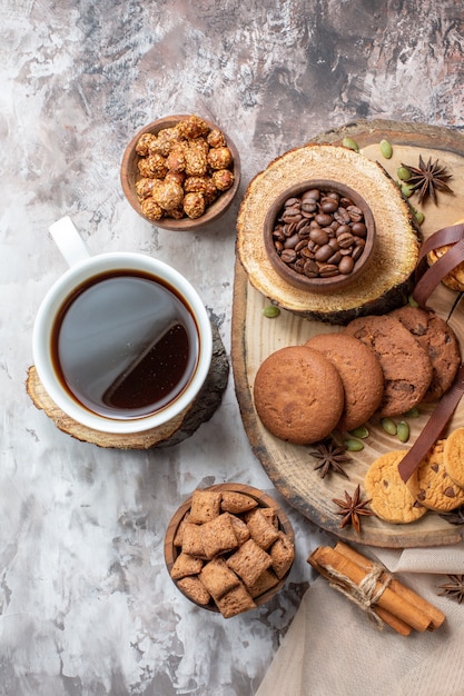 Top view sweet biscuits with nuts and cup of coffee on light desk