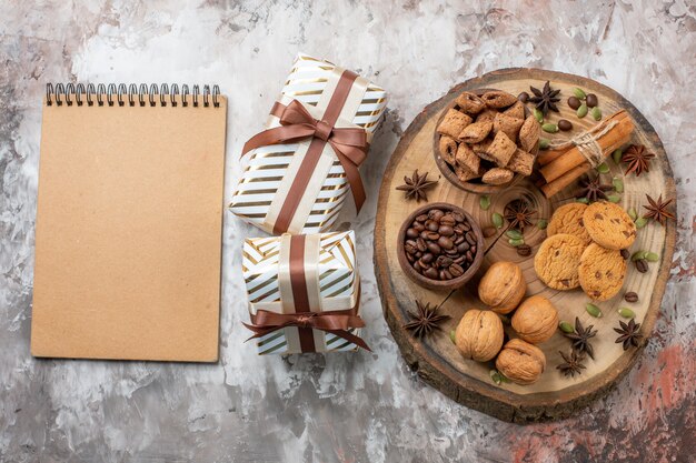 Top view sweet biscuits with presents and walnuts on a light table