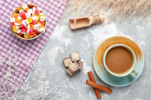 Top view sweet candies with cinnamon and milk coffee on the light background candy sweet sugar photo color