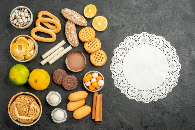 Free photo top view sweet cookies with biscuits and fruits on a grey background