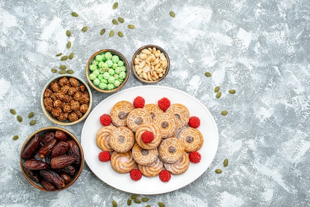 Top view sweet cookies with candies and confitures on a white background cookies sugar biscuit tea sweet cake