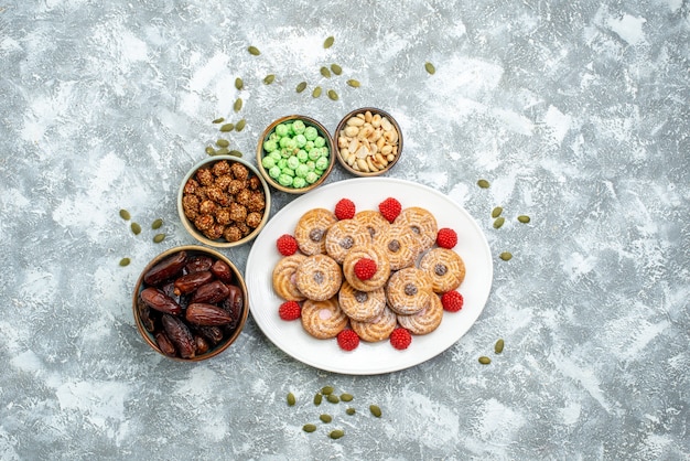 Top view sweet cookies with candies and confitures on white background cookies sugar biscuit tea sweet cake