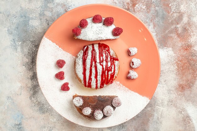 Top view of sweet dessert with sauce on it and berries on side on orange marble background