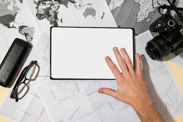 Top view of tablet with hand and world map