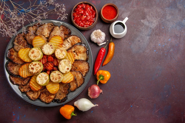 Top view tasty baked vegetables potatoes and eggplants on the dark background meal oven cooking bake vegetables