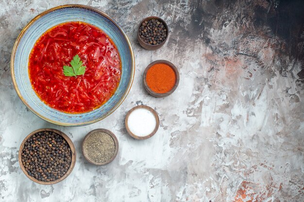 Top view of tasty borsch ukrainian beet soup with seasonings on a white surface