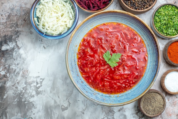 Top view of tasty borsch with seasonings on white surface