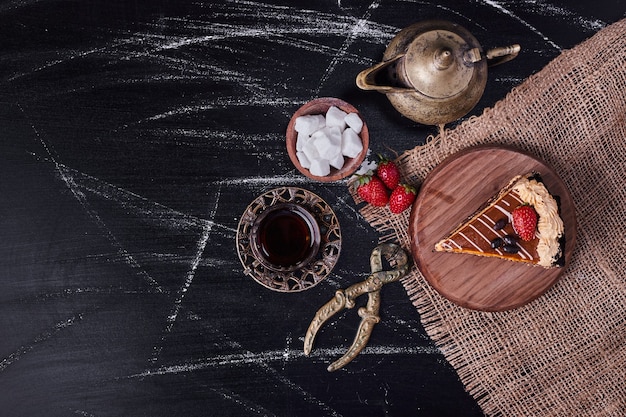 Free photo top view of tasty cake surrounded by tea set on marble table.