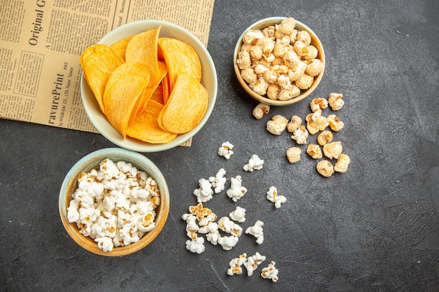 Top view tasty cheese chips with different snacks on dark background