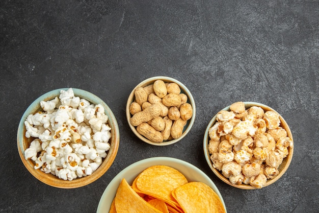 Top view tasty cheese chips with different snacks on dark background