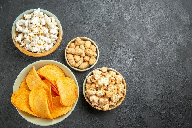 Top view tasty cheese chips with different snacks on dark background