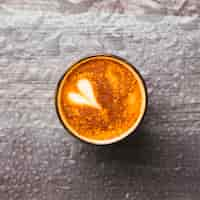 Free photo top view of tasty coffee glass with latte art on water drop background