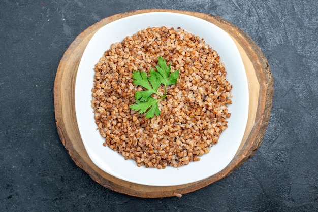 Top view tasty cooked buckwheat inside plate on grey space