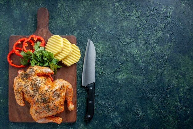 Top view tasty cooked chicken spiced up with potatoes and sliced pepper on dark background meat color dish dinner food barbecue