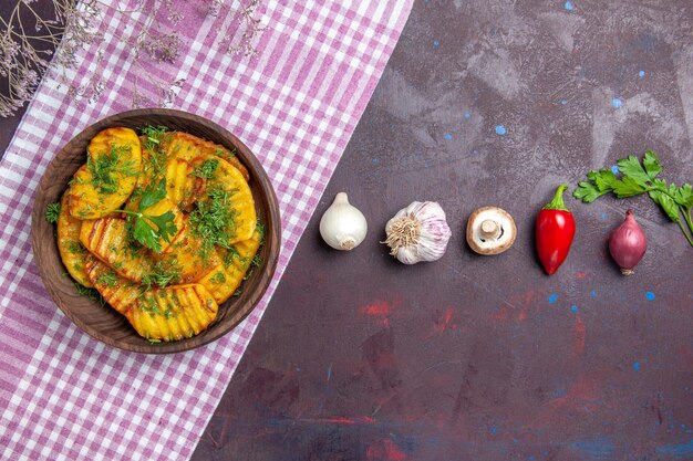 Top view tasty cooked potatoes delicious dish with greens on dark desk potato dinner dish cooking meal