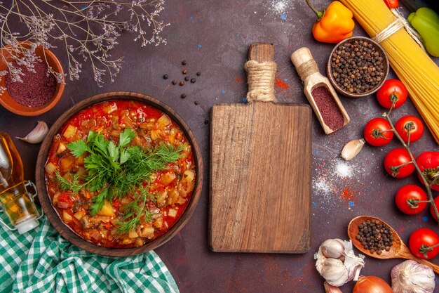 Top view tasty cooked vegetables sauce meal with different seasonings and tomatoes on dark background food sauce meal dish soup