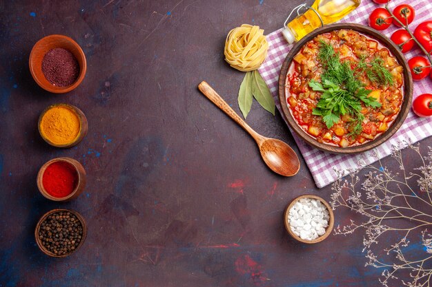 Top view tasty cooked vegetables sauce meal with tomatoes and seasonings on a dark background meal dinner sauce food dish