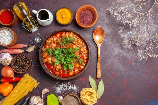 Top view tasty cooked vegetables sliced with sauce and seasonings on dark background sauce soup food dinner meal