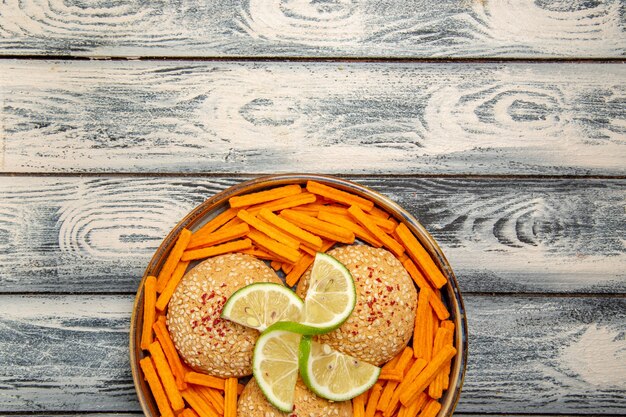 Top view tasty cookies with lemon slices and rusks on rustic grey desk biscuit sugar cake sweet cookie