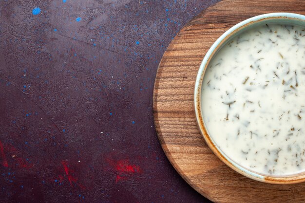 Top view tasty dovga from yogurt with greens inside on dark table, meal food soup green dinner