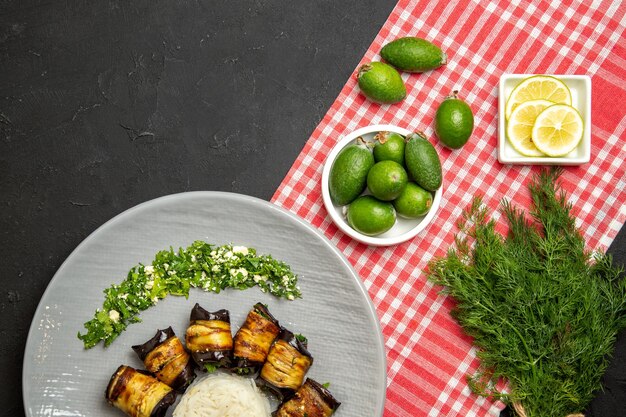 Top view tasty eggplant rolls cooked meal with rice and feijoa on dark surface cooking meal green color dish