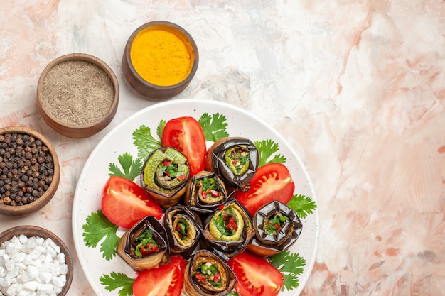 Free photo top view tasty eggplant rolls with greens tomatoes and seasonings