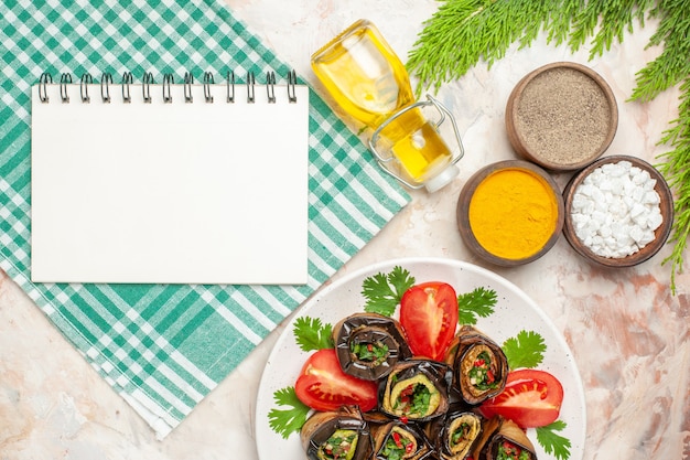 Free photo top view tasty eggplant rolls with seasonings tomatoes and greens