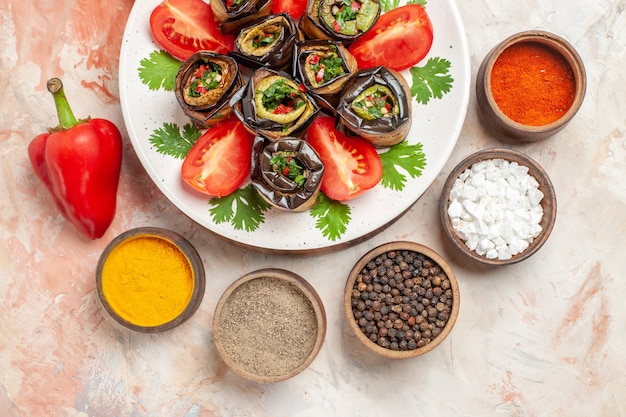 Top view tasty eggplant rolls with tomatoes and different seasonings