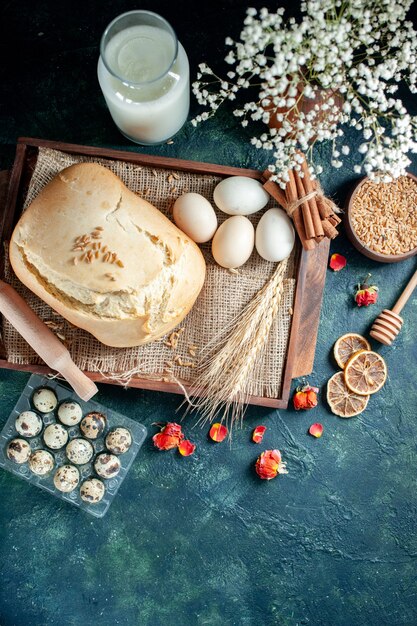 Top view tasty fresh bread with eggs and milk on a dark background cake pie tea sugar bun biscuit breakfast dough bake