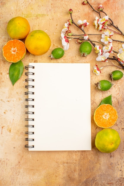 Top view tasty fresh tangerines with feijoas and notepad