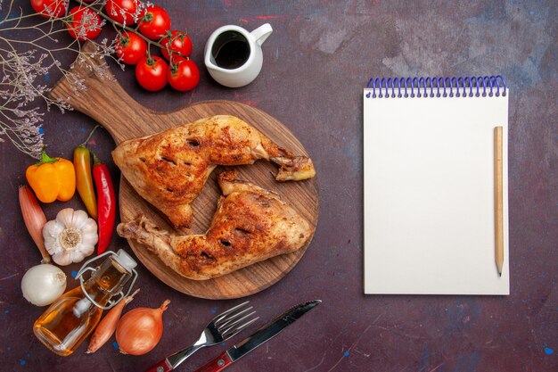 Top view tasty fried chicken with fresh vegetables and seasonings on dark desk food chicken meal vegetable meat