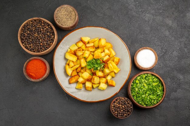 Free Photo top view of tasty fried potatoes inside plate with seasonings on the dark surface