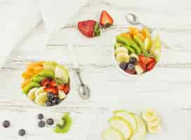 Free photo top view tasty fruit salads surrounded by fruit