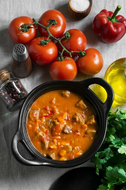 Top view tasty goulash and tomatoes