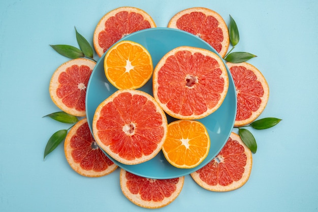 Top view of tasty grapefruits fruit slices on blue surface