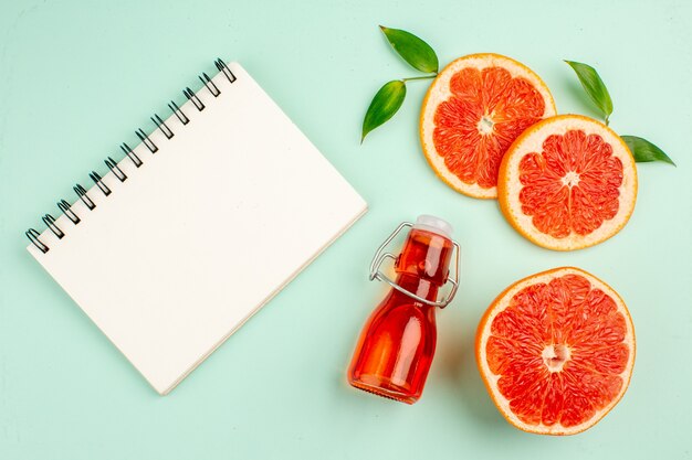 Top view of tasty grapefruits sliced juicy on light-blue surface