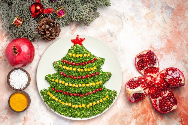 Top view tasty green salad in new year tree shape with seasonings on light desk holiday meal health xmas color photo