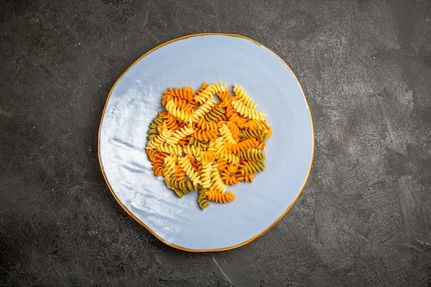 Top view tasty italian pasta unusual cooked spiral pasta on dark