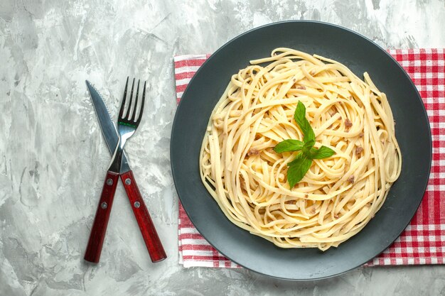 Top view tasty italian pasta with cutlery on white background