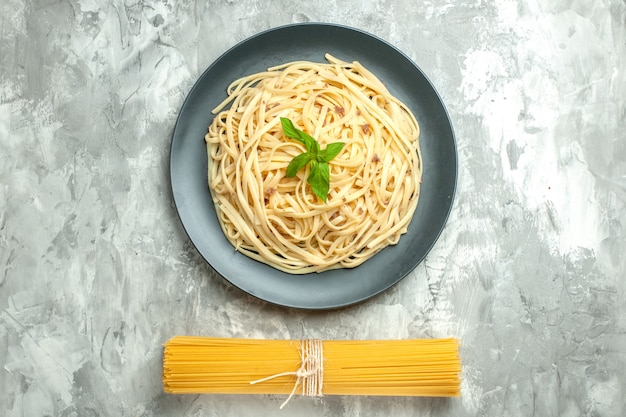 Free photo top view tasty italian pasta with raw pasta on the white background