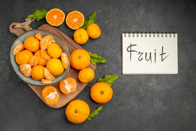 Free photo top view tasty juicy tangerines inside plate on dark background