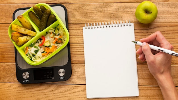 Free photo top view tasty meal arrangement with empty notebook