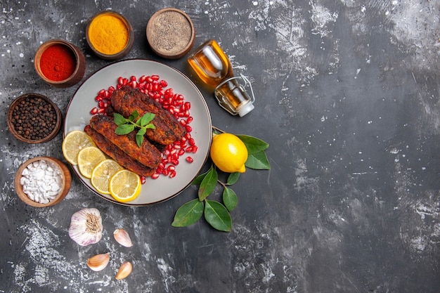 Top view tasty meat cutlets with seasonings on the grey background meal food dish