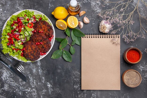 Top view tasty meat cutlets with vegetable salad on a grey background dish photo food meal