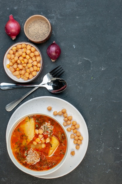 Free photo top view tasty meat soup consists of potatoes meat and beans on dark background