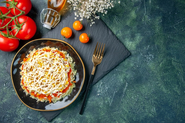 Top view of tasty mimosa salad inside plate on dark blue surface