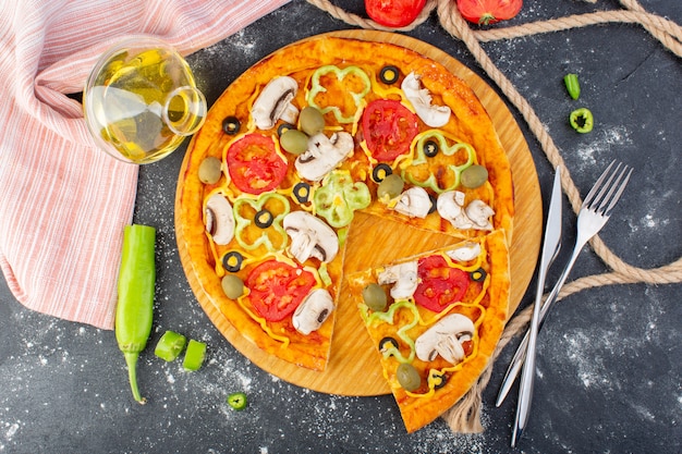 Free photo top view tasty mushroom pizza with red tomatoes green olives mushrooms with fresh tomatoes and oil all over the grey desk pizza dough meat